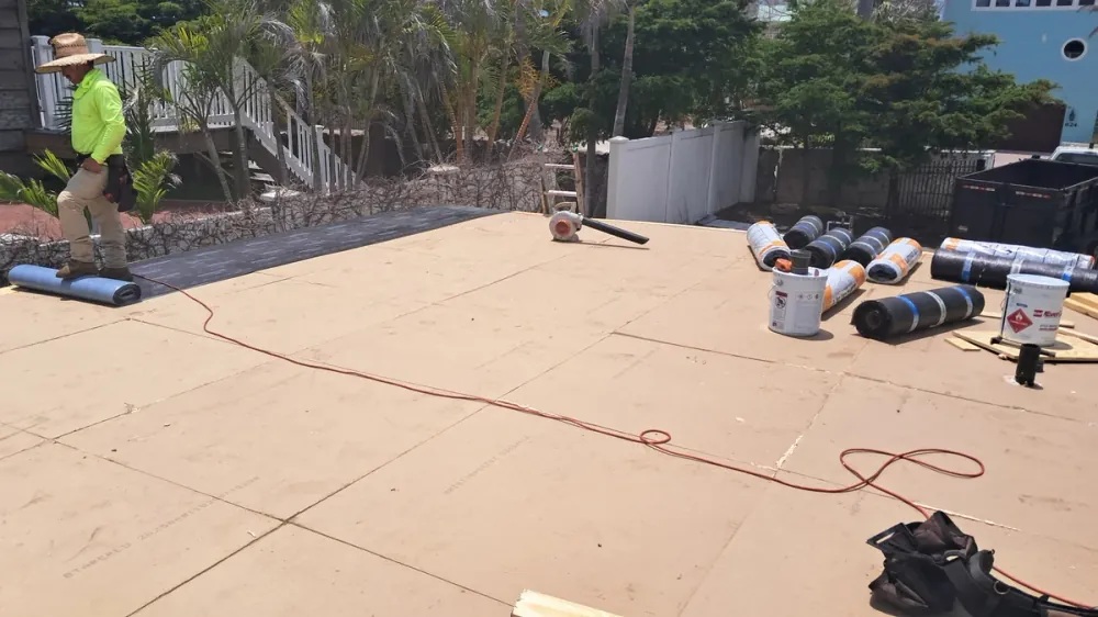 Crew installing modified bitumen membrane over OSB deck in Sarasota